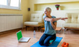 Senior woman doing yoga in living room