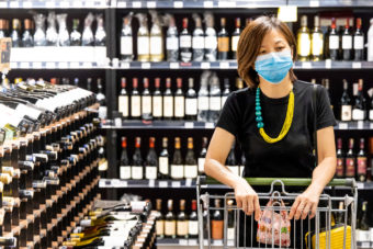 Woman with mask shopping in liquor store
