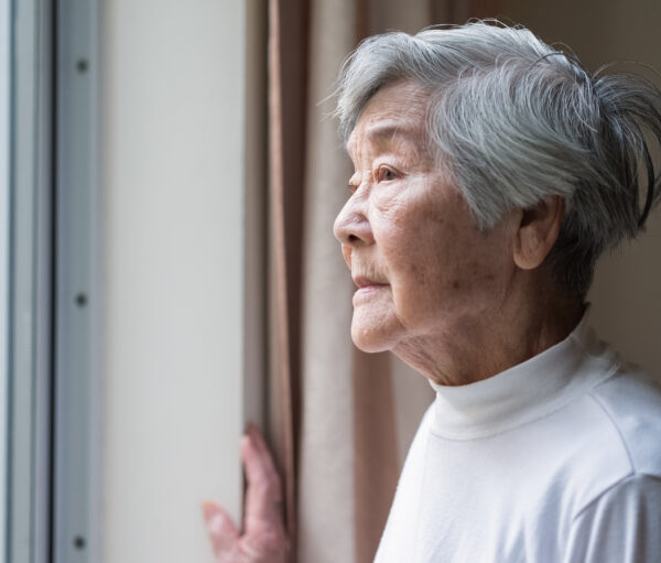 Chinese senior woman looking outside.